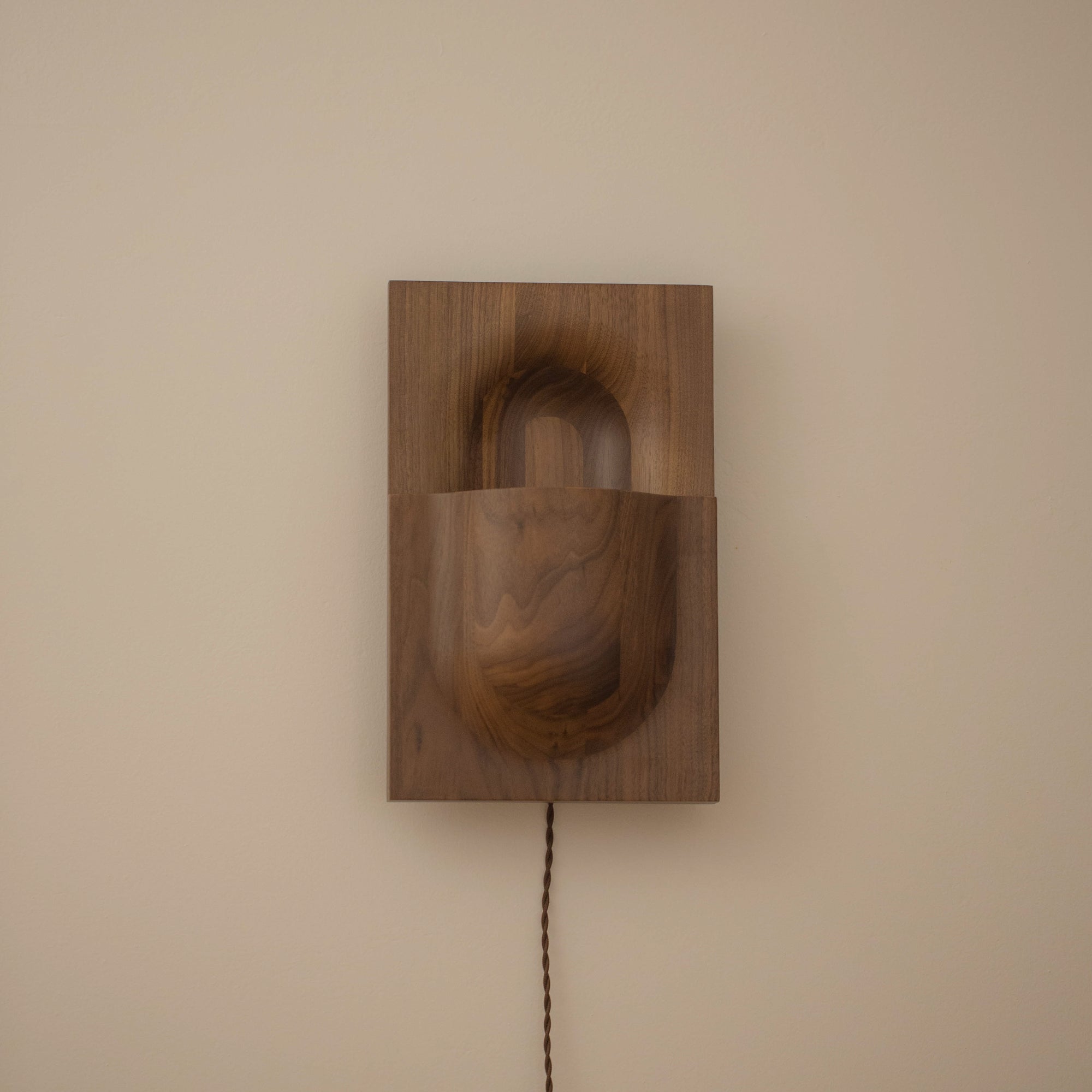 PARCTA Circuit Sconce wall light mounted on a wall, featuring a sleek, modern design with a round shade and minimalist metal arm.